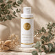 Curlizz Leave-In - Flacon avec clip sur fond beige et verdure
